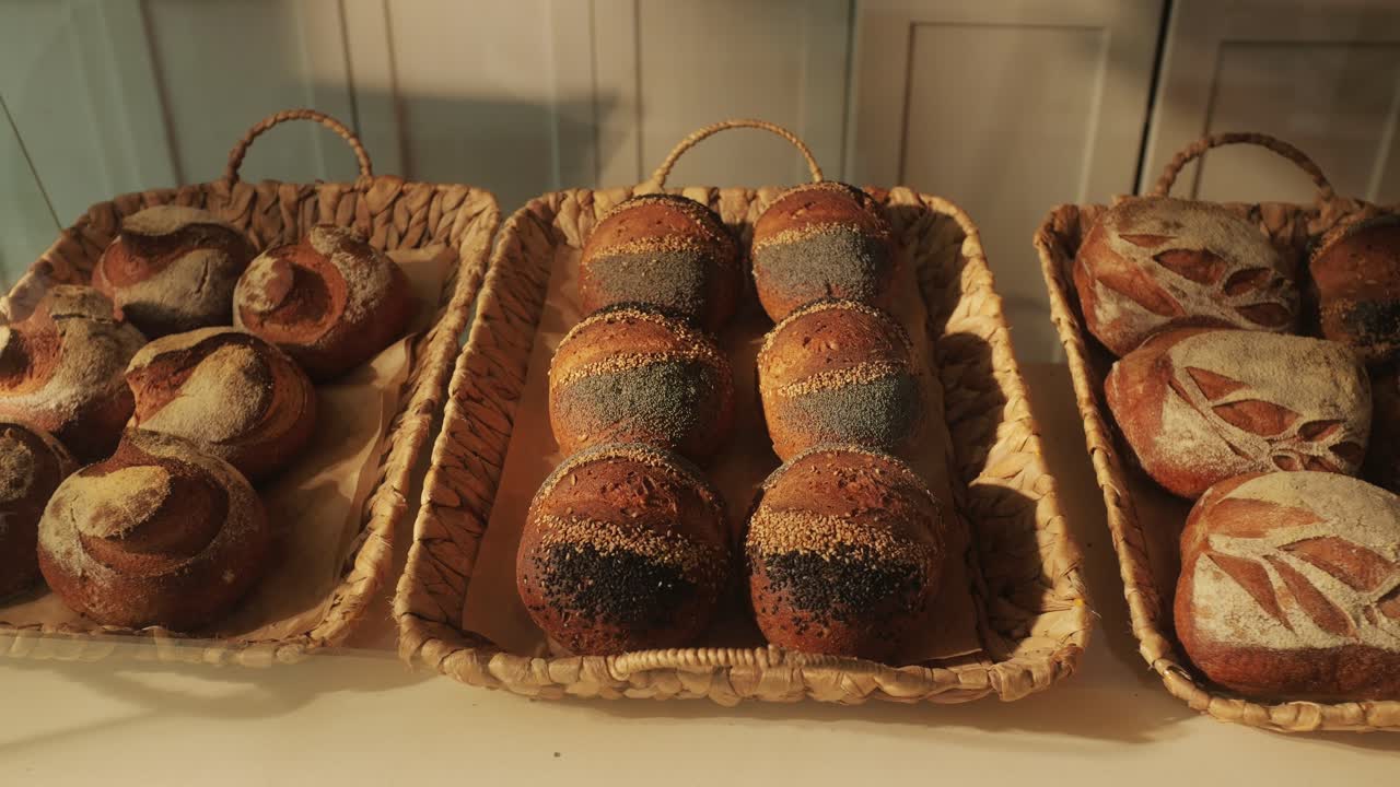 Fresh artesian bread on bakery shop close-up. Bread with black poppy garnish on top and white flour on top. Artisan bread is making by skill bakers using natural and high-quality ingredients. Food with health and flavour benefits.