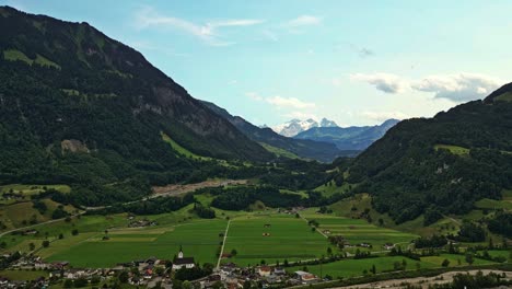 drone shot of a small village surrounded by the swiss alps, brienzer rothorn mountain in emmental alps, switzerland, europe