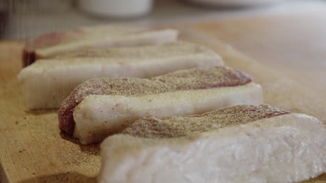 Seasoning-meat-steaks-with-pepper,-garlic-powder-and-rosemary-powder