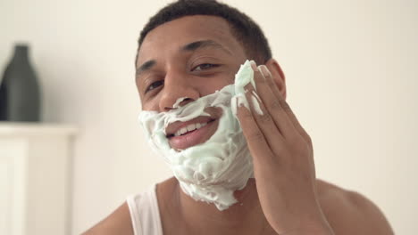 portrait of handsome black man applying shaving foam