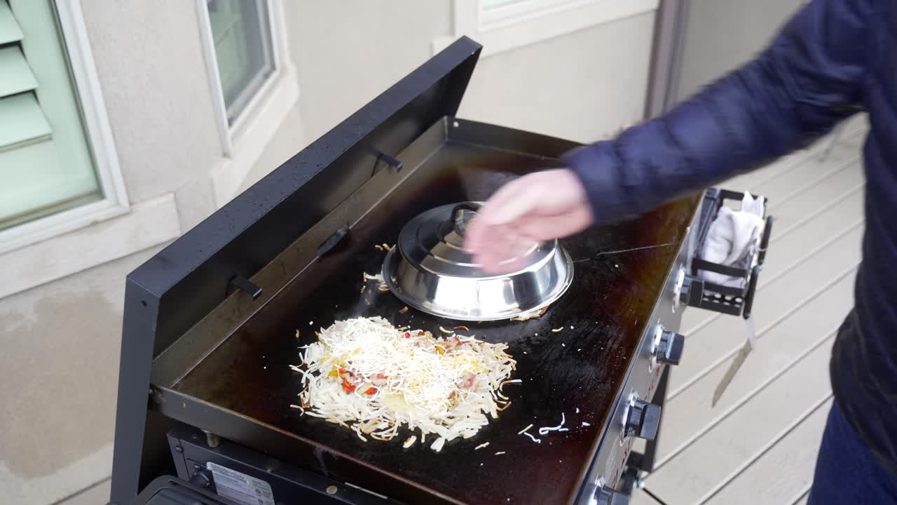 계란 위에 치즈를 추가하여 플랫 탑 철판에 해시 브라운 오믈렛 만들기