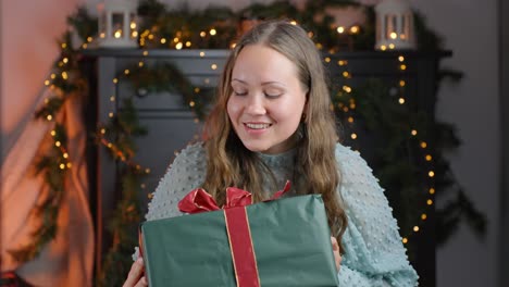 woman shaking gift box guessing what's inside while smiling, static closeup