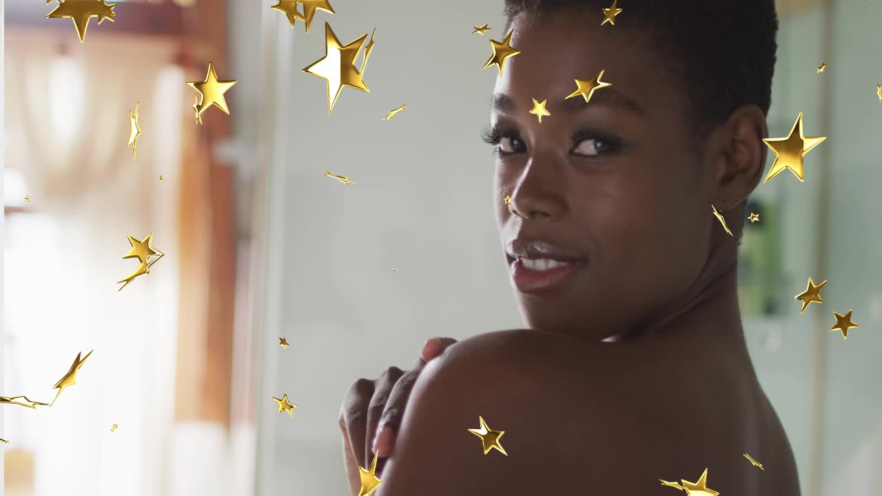 Woman responding to camera, turning to face lens, smiling with gold stars drifting around portrait