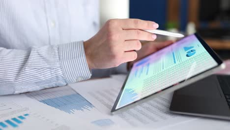 businesswoman studying business analytics in charts on tablet closeup