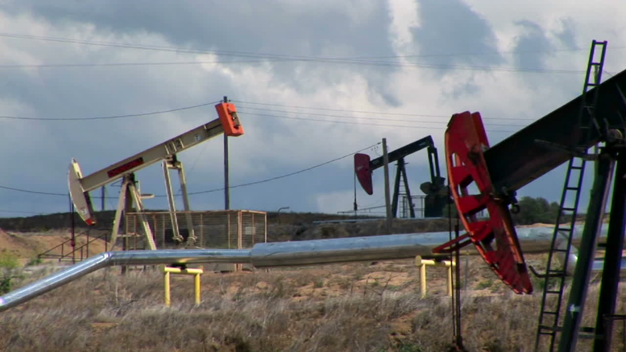 gatos de bomba se mueven hacia arriba y hacia abajo en un campo petrolero