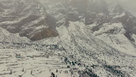 Drone-footage-looking-up-at-a-mountain-covered-in-snow-in-Naltar-Valley-Gilgit-revealing-shot