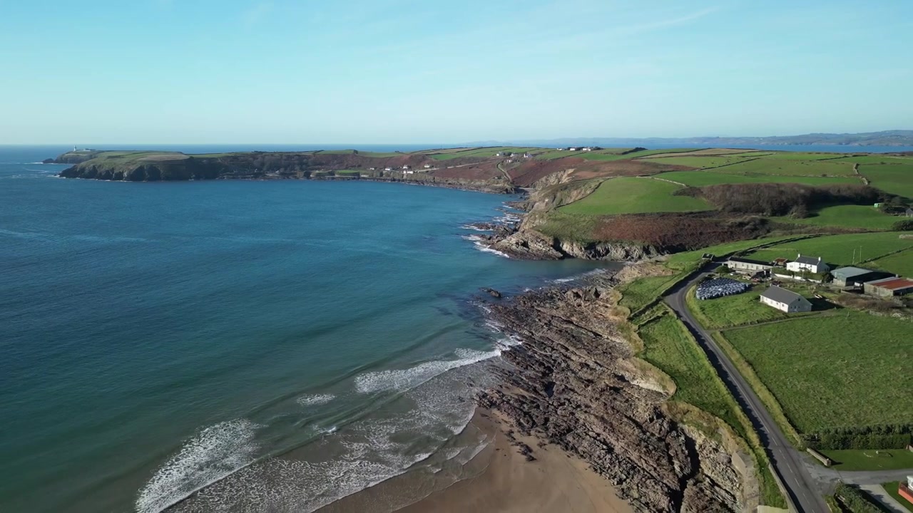 Drone luftfoto over kystnære West Cork med Red Strand og Galley Head forbjerget, roligt Atlanterhav i Irland.