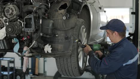 mechanic repairing car engine in auto workshop