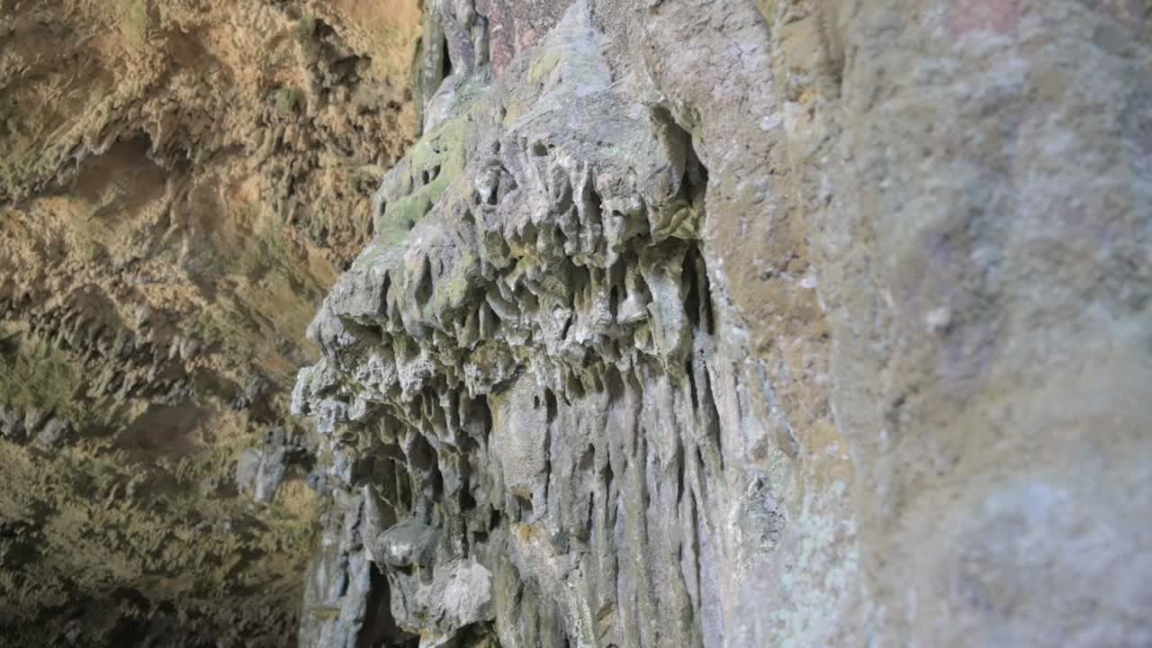 formaciones rocosas dentadas y en capas en tonos de marrón y gris dentro de la cueva de murcielago