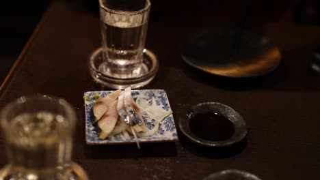 person preparing and serving sashimi on a plate