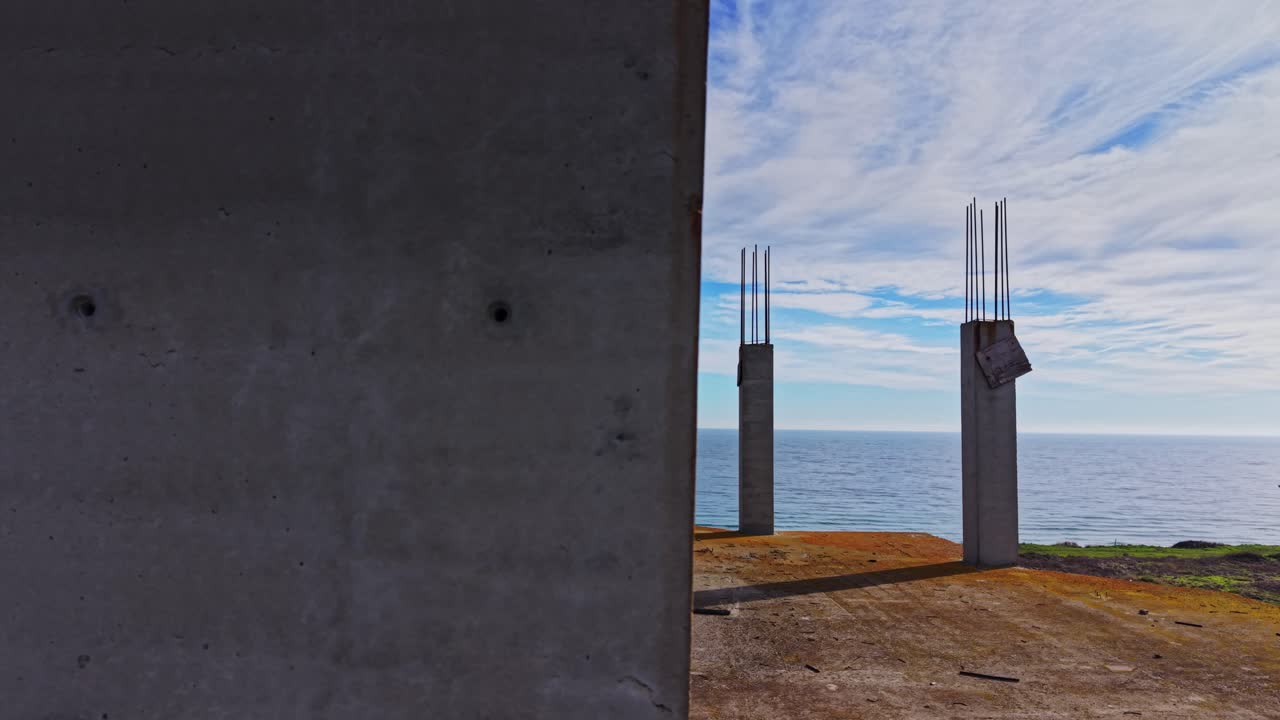 Aerial view showcasing unfinished concrete structure by the ocean