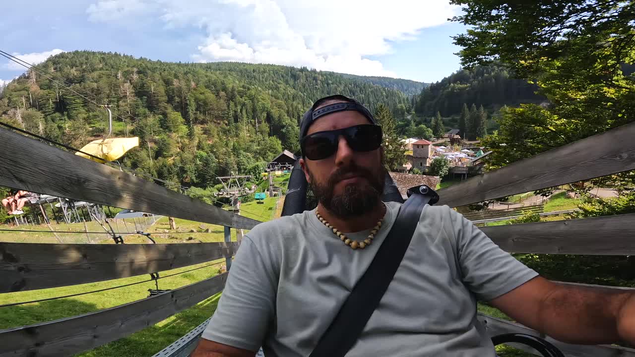 Manzaralı bir dış mekanda bir adamın kızakla kaymasının keyfini çıkarması