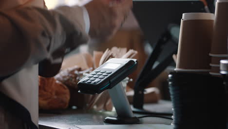 close up customer paying using credit card contactless payment in cafe spending money with wireless transaction in restaurant coffee shop