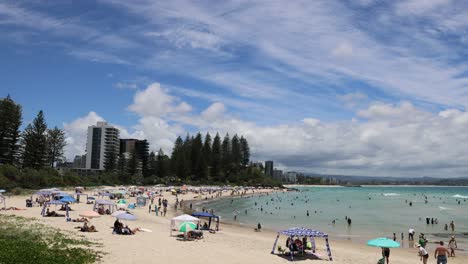 crowded beach scene with changing cloud patterns