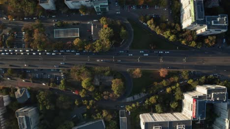 Trams-and-cars-in-bucharest-during-autumn,-golden-sunlight,-aerial-view