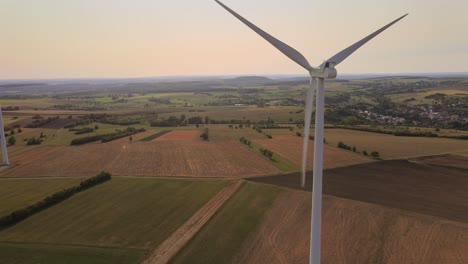 Drone-flying-forwards-wind-turbines-rotating-on-rainfed-crop-fields-in-France