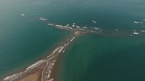 agua tranquila bañándose en arena dorada en el parque nacional marino ballena, conocido como playa de cola de ballena en uvita, costa rica