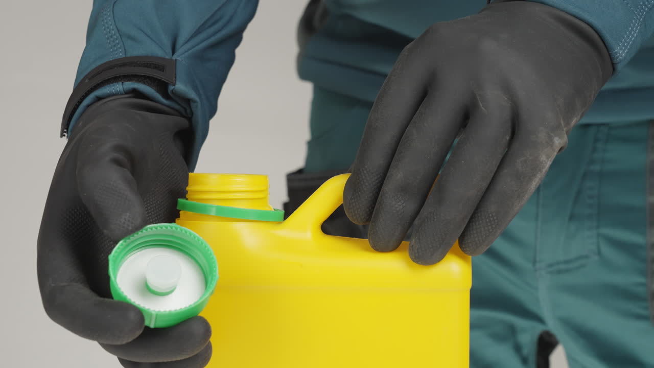 persona con guantes abriendo un recipiente de plástico amarillo