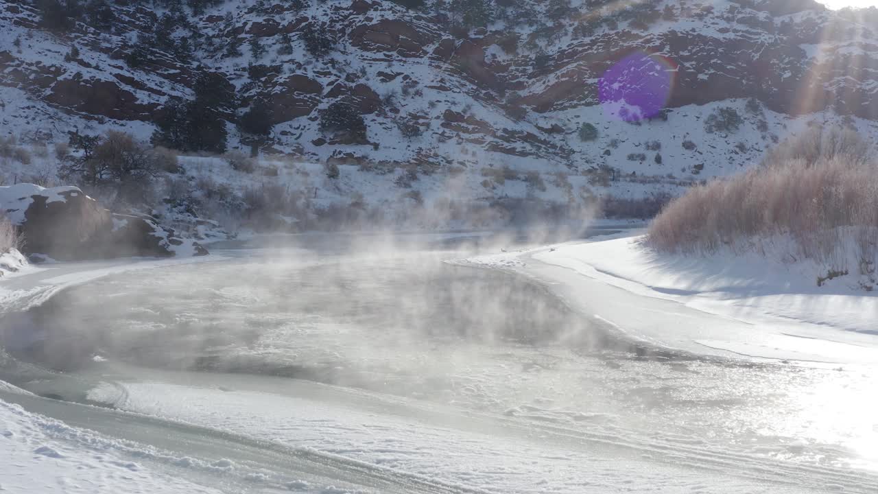 río de montaña temprano en la mañana con nieve, niebla y hielo