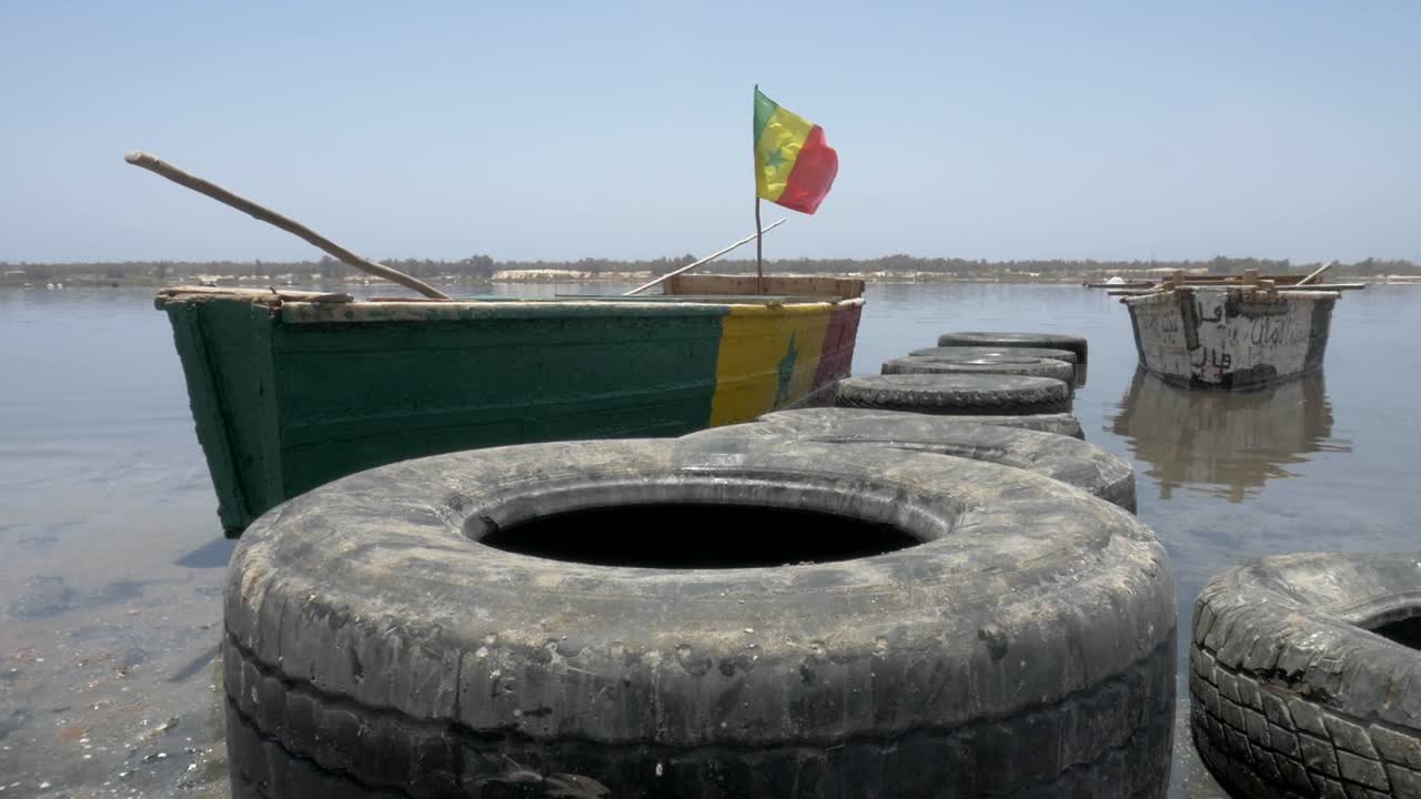 세네갈의 분홍색 호수에서 부드러운 크레인 안정화와 함께 보트의 영화 촬영