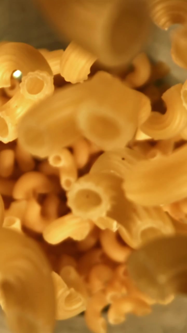 Maccheroni secchi che cadono al rallentatore in primo piano