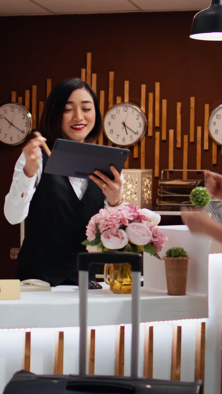 Video verticale: turista asiatica firma file di registrazione elettronica su tablet