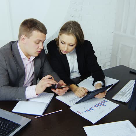 dos jóvenes socios comerciales emprendedores trabajan en una tableta