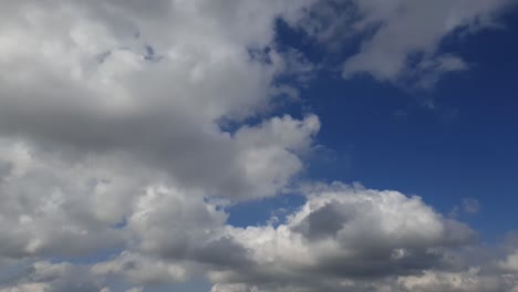 Blauer-Sommerhimmel-Mit-Dichten,-Dicken-Regenwolken,-Die-Sich-über-Den-Himmel-Bewegen