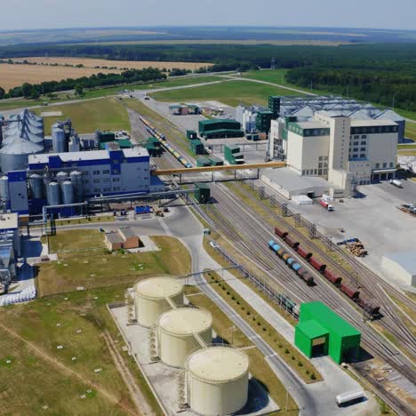 agribusiness on field. modern industrial territory. metal silo for storing grains. manufacturing for grain storage among fields and forests. aerial view.