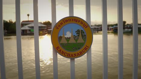 tourism sign on railing by waterfront harbor at sunset in thailand