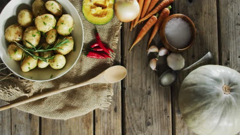 Overhead-view-of-cooked-potatoes-and-multiple-food-ingredients-on-wooden-surface