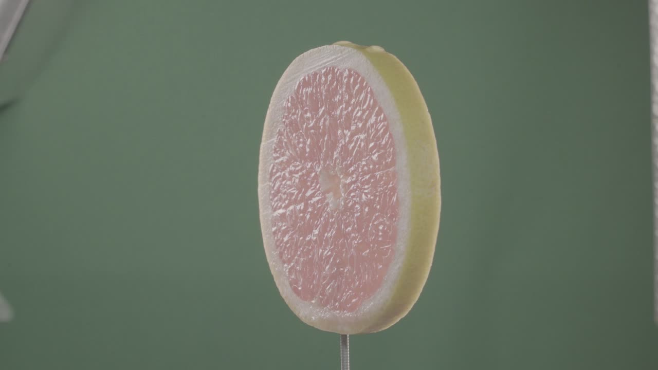 크로마 키를 위해 그린 스크린에 루프와 함께 회전하는 그레이프프루트