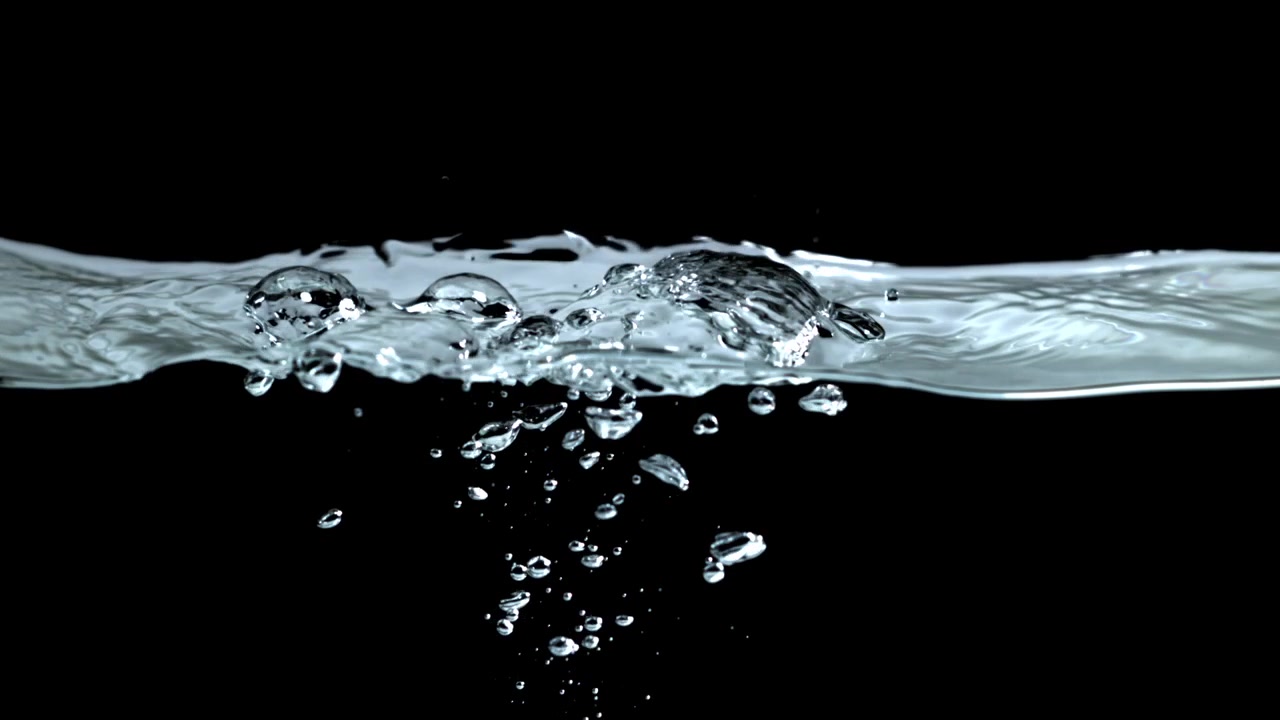 Bolle in risalita in acqua limpida al rallentatore su sfondo nero