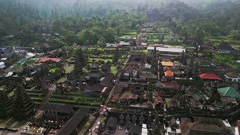 scenic drone video capturing besakih temple, a historic spiritual complex on mount agung’s slopes, showcasing ancient stone structures, ceremonial staircases, and lush verdant surroundings in bali