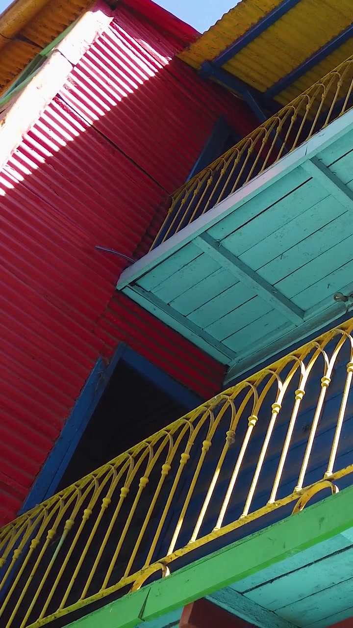 Corrimão de varanda em La Boca, com arquitetura de ferro corrugado do cortiço Caminito, capturado com smartphone vertical, na cidade de Buenos Aires, Argentina.