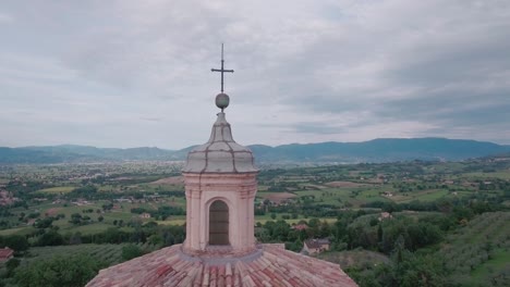 aerial drone shot crane up and fly past church with birds into countryisde in umbria, italy
