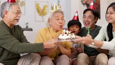 elderly family members and children enjoy a joyful birthday celebration with cake, candles, and laughter in a cozy setting