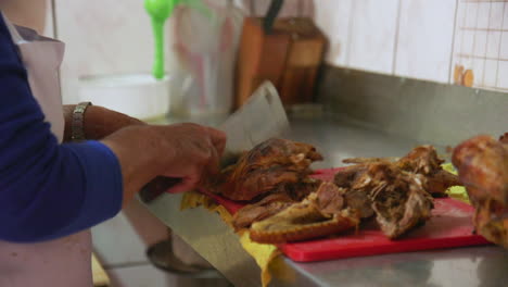 una mujer peruana mayor cortando un pato entero en un mostrador de cocina con una cuchilla