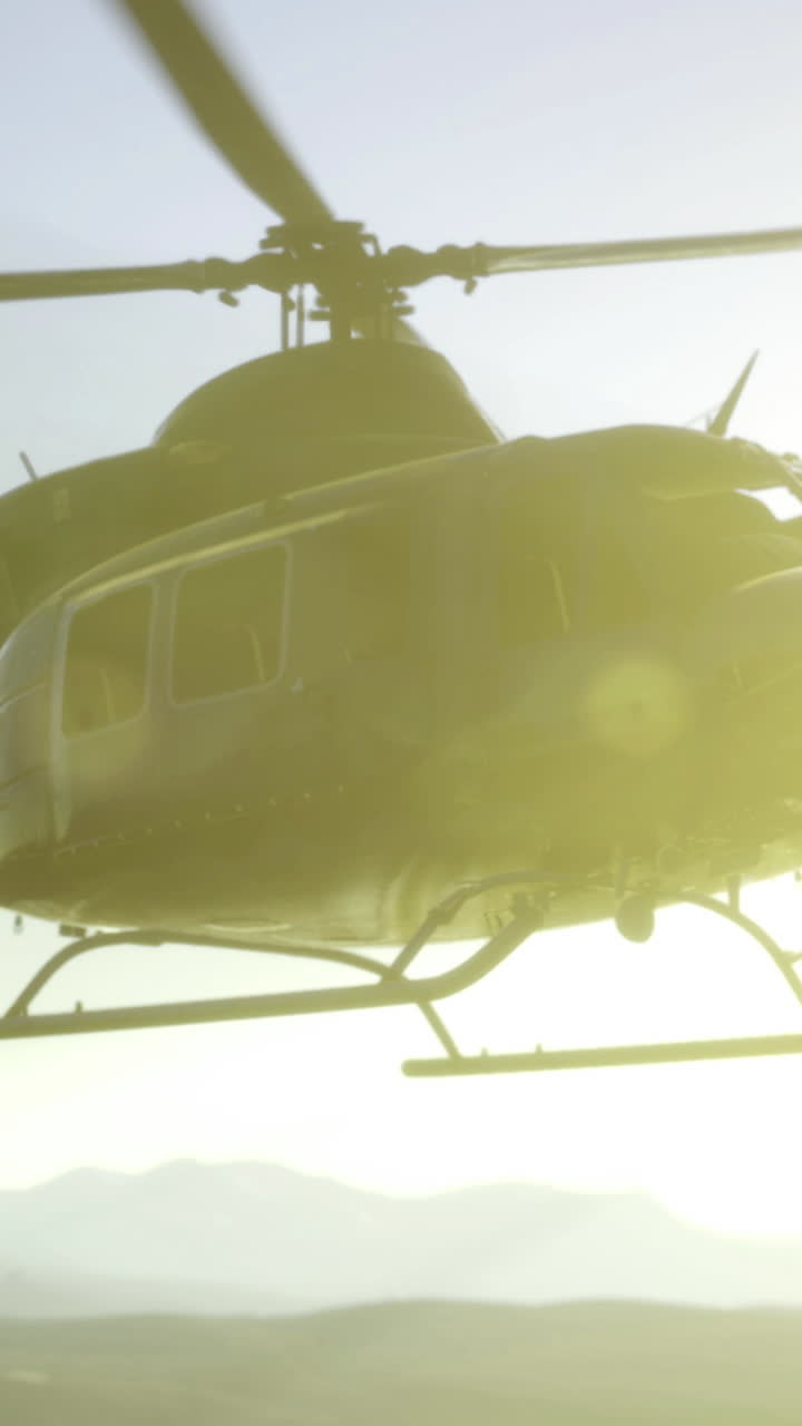 Helicóptero sobrevoando montanhas ao pôr do sol durante um voo aventureiro