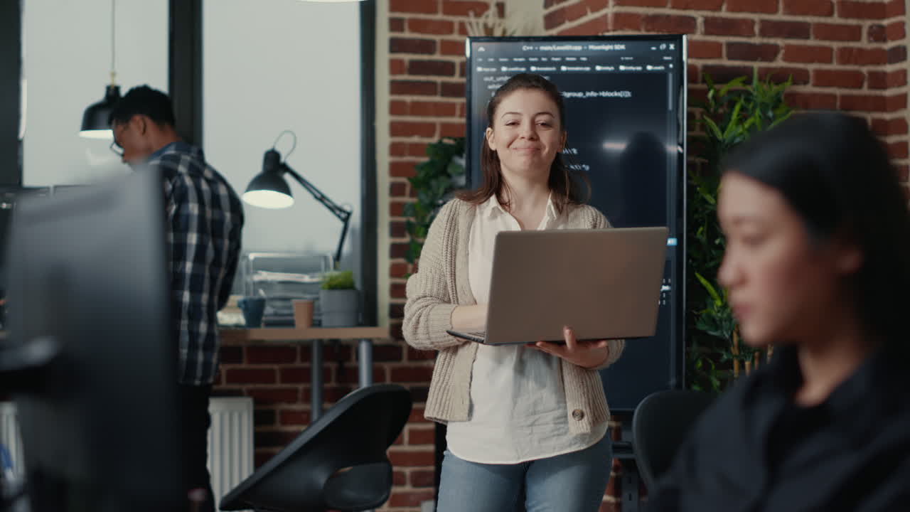 Portrait of caucasian app developer holding laptop looking up and smiling