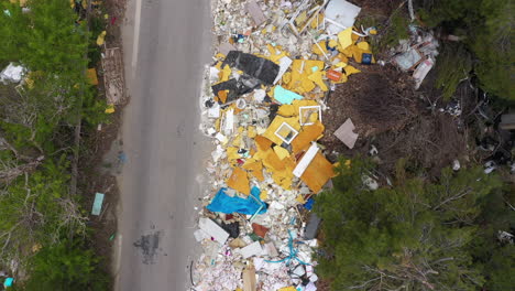 Garbages-along-an-asphalt-road-unauthorized-dumping-aerial-drone-view-France