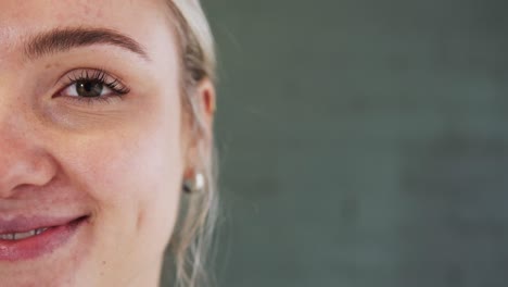 medio retrato de una joven caucásica contra una pared de ladrillo gris con espacio de copia