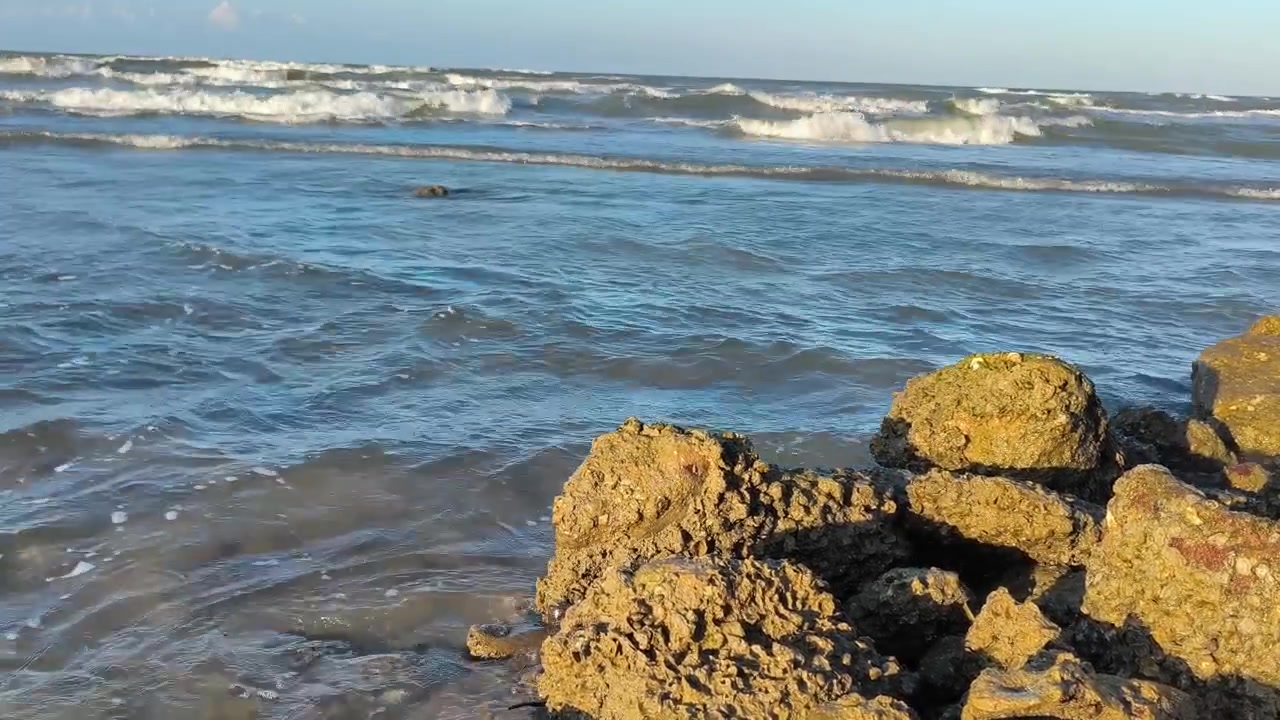 Le onde dell'oceano si schiantano contro la costa rocciosa