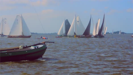 Traditional sailing boat regatta with a historic cargo sk&ucirc;tsje passing in front of the camera