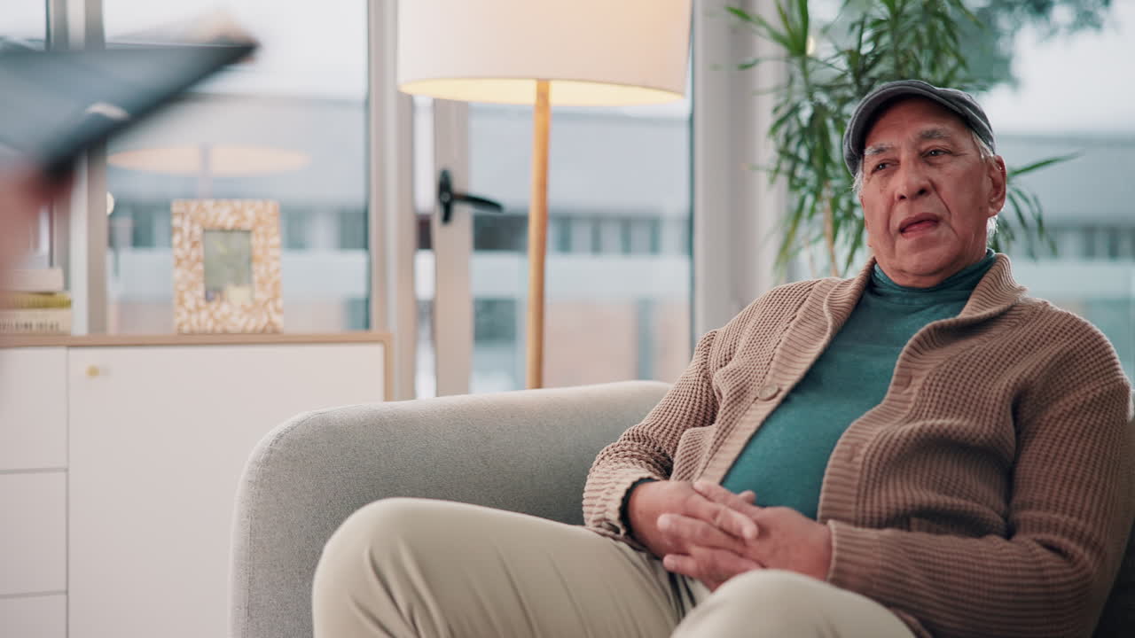 An elderly man is visited by his doctor in his home for a medical consultation