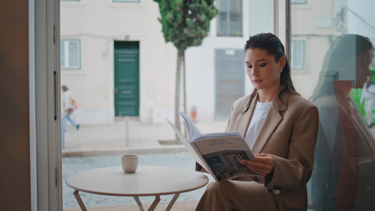 Lady boss reading magazine in small cozy restaurant close up. Calm businesswoman