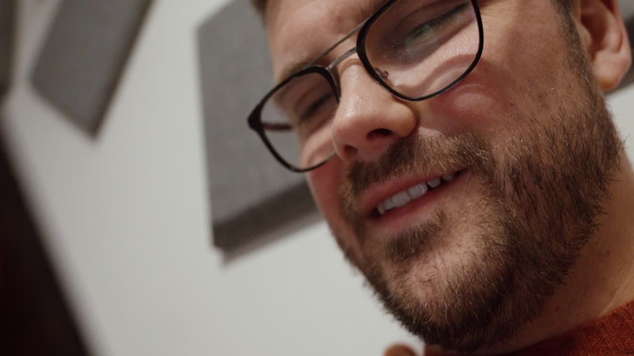 A man closely examining his smartphone, captured in both close-up and wide-angle shots, illustrating focus, communication, and everyday mobile phone use