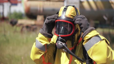 worker in hazmat suit putting on respirator