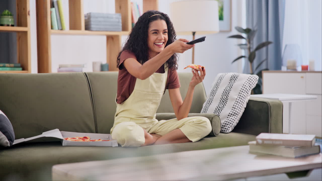 Kvinde ser tv og spiser pizza