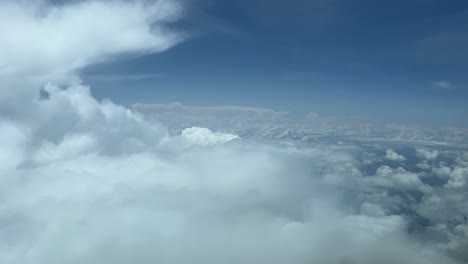 el punto de vista de un piloto desde una cabina de un avión volando sobre nubes esponjosas a 8000 m de altura